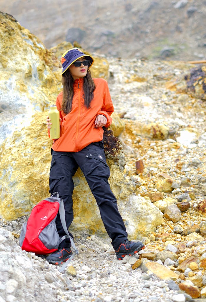 A female hiker in bright outfit exploring rocky terrain in West Java, Indonesia.